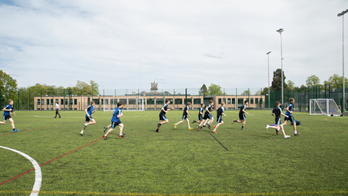 Pupils playing football on football pitch